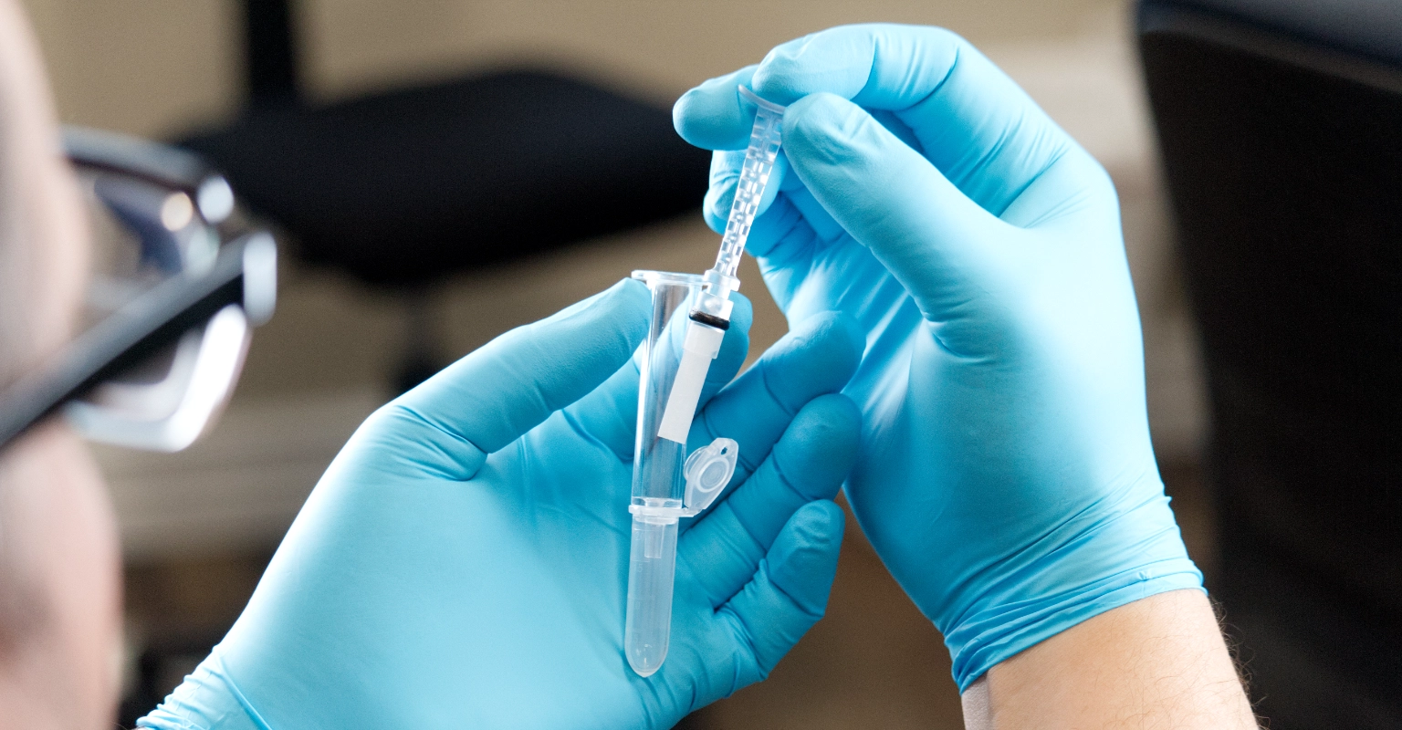 Gloved hands handling OraConfirm™ in a clinical workflow